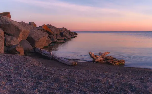 Holzstücke Und Felsen Ufer Eines Meeres Während Des Sonnenuntergangs — Stockfoto