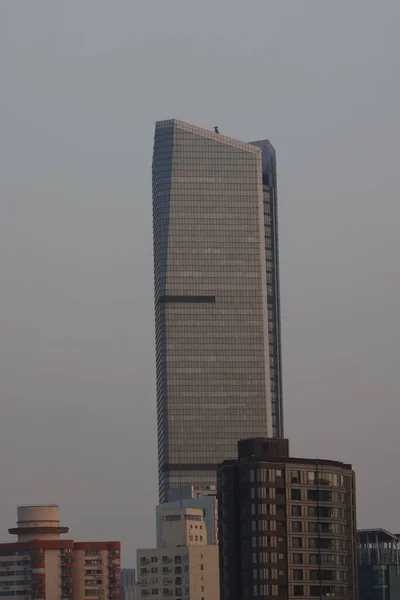 Высокое Стеклянное Здание Выглядывающее Других Зданий — стоковое фото