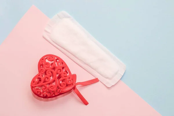 生理用生理用ナプキンは 紙の背景に赤い心を持つ供給 — ストック写真