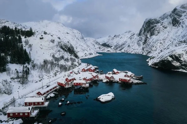 冬の曇りの日にロフトテン諸島のヌスフィヨルドの小さな漁村のドローン写真雪に覆われた山々に囲まれた — ストック写真