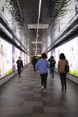 Şangay 'da bir yeraltı tünelinde yürüyen insanlar.