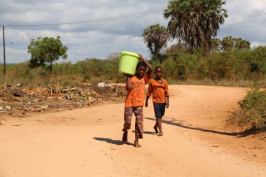 Kenya, Ukunda 'da kovalarla su taşıyan yerel çocuklar.