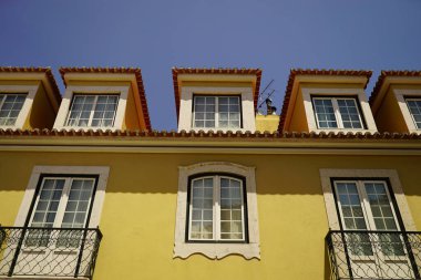 Eski sarı bir binanın alçak açılı görüntüsü.