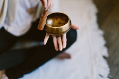 Tibet meditasyon kasesi kullanan bir kadının açı çekimi..