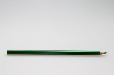 Beyaz bir yüzey üzerindeki yeşil renkli bir kalemin fotokopi alanı ile yakın plan görüntüsü.