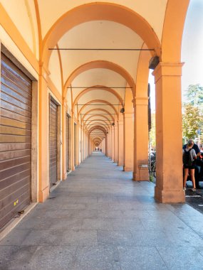 Bologna 'daki atari salonlarından birinde sol tarafta mağazalar ve sağ tarafta park yerleri olan bir patika.