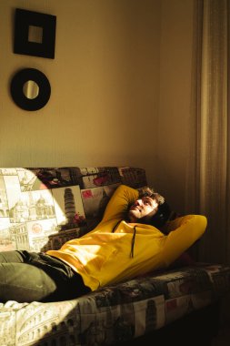 Sarı kapüşonlu genç, yakışıklı bir İspanyol altın saatin parlak güneş ışığının tadını çıkarıyor.