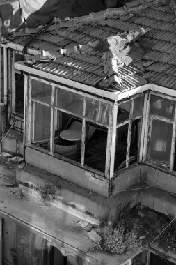 Eski ve grunge bir binanın dış yüzeyinin dikey gri tonlama görüntüsü.