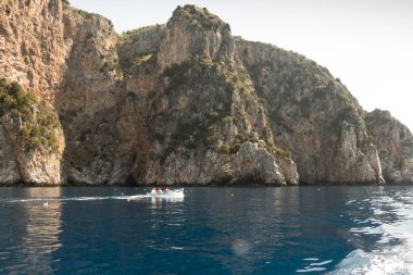 İtalya 'nın Centola kentindeki Marinella' da açık bir gökyüzüne karşı mavi sudaki kayalık uçurumların güzel manzarası.