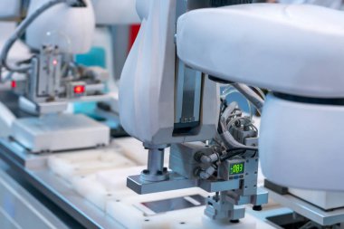 Robot kolların yakın plan çekimi modern fabrikada akıllı telefon montajı
