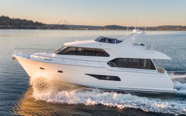 Su sıçramasıyla denizde yüzen beyaz bir yat.