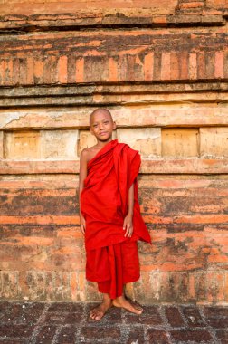 Geleneksel kırmızı Burma kıyafeti giyen mutlu bir çocuk.