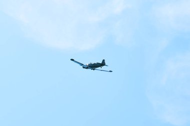 Mavi arka planda askeri bir jetin alçak açılı görüntüsü.