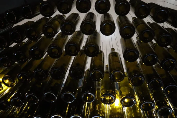 低角度のワインボトルには ワイナリーの天井から吊るされたシャンデリアが特徴です — ストック写真