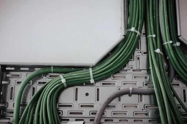 銀の壁の背景に接続された緑の配線のクローズアップショット — ストック写真