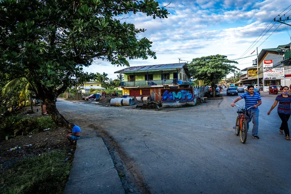 在哥斯达黎加的一座五彩斑斓的建筑物前 人们骑着自行车在十字路口行走的镜头 — 图库照片