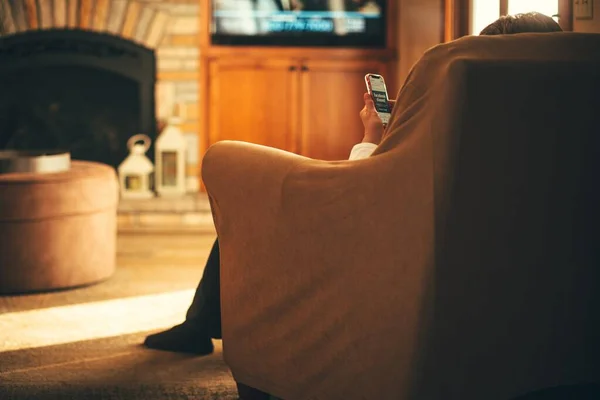 Enfoque Superficial Una Persona Sentada Sofá Mirando Teléfono Sala Estar — Foto de Stock