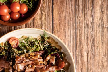 Bir kasede Insalata Tiepida 'nın diğer kasede fotokopi uzayı olan vişneli domateslerin yanında..