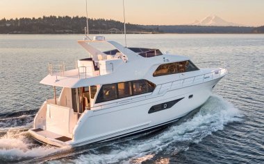 Su sıçramasıyla denizde yüzen beyaz bir yat.