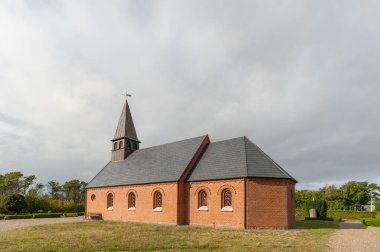 Gündüz vakti gri bulutlu gökyüzünün altındaki Danimarka 'daki Hulsig Kilisesi