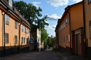 Stockholm, İsveç 'te güneşli bir günde taş binaların olduğu bir ara sokak.