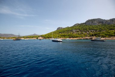 Yunanistan 'ın Hydra adasındaki yeşil bir arazide yelken açan teknelerin görüntüleri