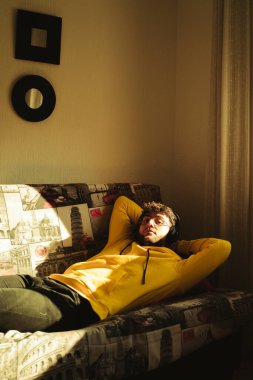 Sarı kapüşonlu genç, yakışıklı bir İspanyol altın saatin parlak güneş ışığının tadını çıkarıyor.