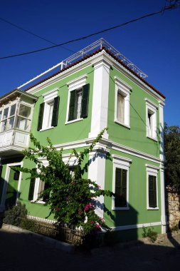 Kasabada yeşil boyalı, modern, iki katlı bir evin dikey görüntüsü.