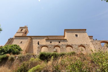 Alcala del Jucar tepesindeki bir kalenin alçak açılı görüntüsü bulutsuz bir gökyüzüne karşı.