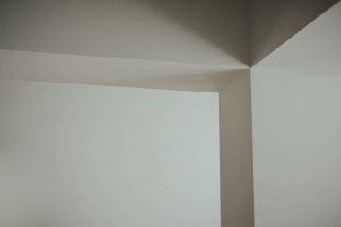 Modern evdeki beyaz bir duvarın üzerine gölgeler düşmüş.