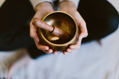 Bir kadının ellerinin Tibet meditasyon kasesini tutarken çekilmiş en iyi fotoğrafı..