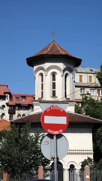 ルーマニアのブカレスト旧市街を背景に古い教会と赤い円の交通標識の垂直ショット — ストック写真