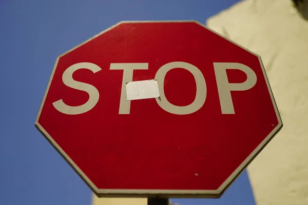 Alacsony Szögű Felvétel Utcanévtábláról Stop Felirattal Egy Piros Táblán Homályos — Stock Fotó