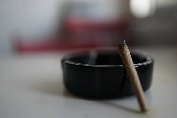 Primer Plano Cenicero Con Cigarrillo Sobre Mesa Con Fondo Borroso —  Fotos de Stock