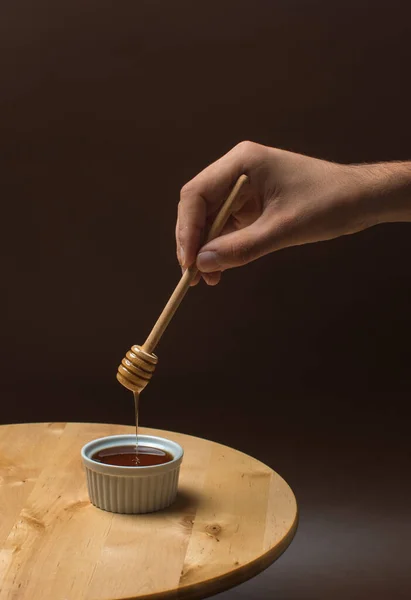 Een Hand Met Een Houten Honinglepel Een Kom Lekkere Honing — Stockfoto