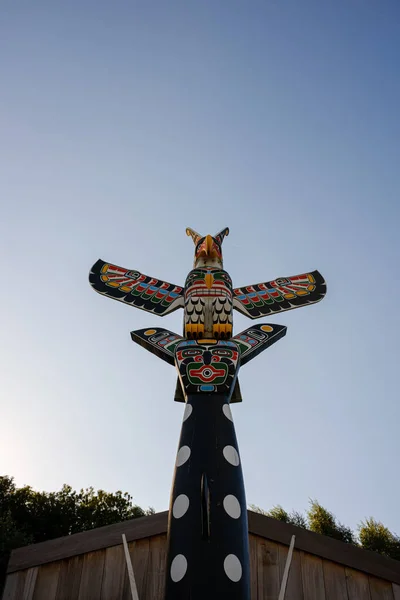 一个加拿大风格的图腾杆的垂直镜头 它与作为伟大信使的鹰动物在一起 — 图库照片