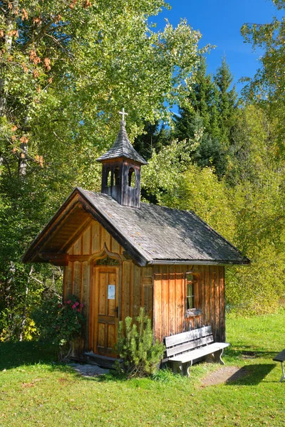 緑の木々や草に囲まれた美しい木製の礼拝堂の垂直ショット オーストリアのチロルに宗教的な建物 森の中の自然霊 — ストック写真