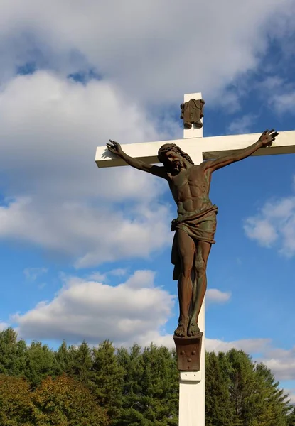 Metallskulptur Von Jesus Christus Auf Weißem Holzkreuz Außerhalb Mit Bäumen — Stockfoto