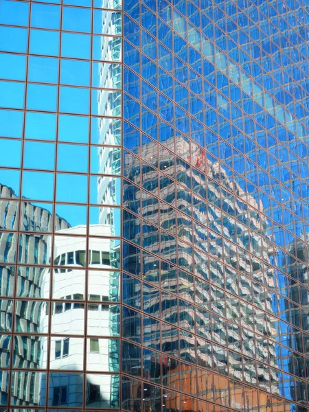 Vertikal Bild Modern Glashusvägg Som Reflekterar Byggnaderna Runt Omkring Den — Stockfoto