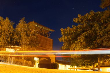 Taize 'nin çanları. Önünden bir araba geçiyor. Arabadan hafif çizgiler. Taize 'nin çan kulesi.