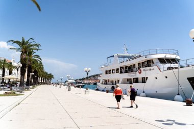Hırvatistan 'ın Trogir kentinde kenetlenmiş bir yolcu gemisinin yanından geçen turistlerin güzel bir görüntüsü