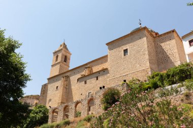 Alcala del Jucar tepesindeki bir kalenin alçak açılı görüntüsü bulutsuz bir gökyüzüne karşı.
