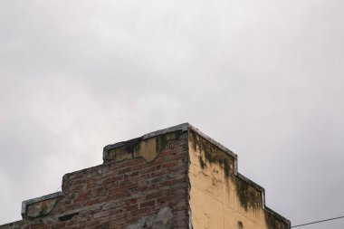 Gri gökyüzüne karşı eski bir tuğla evin alçak açılı görüntüsü