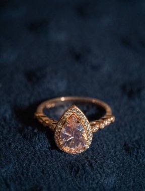 Mavi arka planda bir elmas yüzüğün dikey görüntüsü