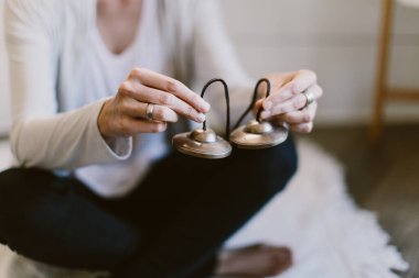 Tibet meditasyon çanlarını tutan bir kadının yakın plan fotoğrafı..