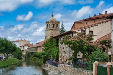 İspanya, Aguilar de Campo 'da güzel bir bina manzarası ve bir nehir.