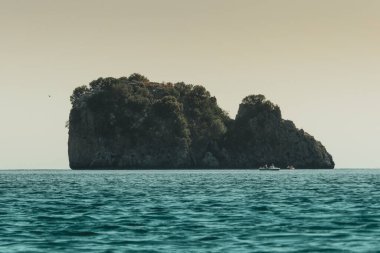 İtalya 'nın Centola kentindeki Marinella' da açık gökyüzü olan mavi sudaki kayalık bir uçurumun güzel manzarası.