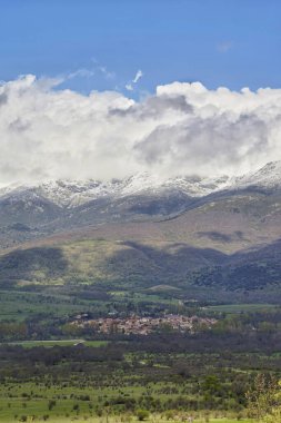 Bulutlu gökyüzünün altındaki bir dağ sırasının dikey görüntüsü