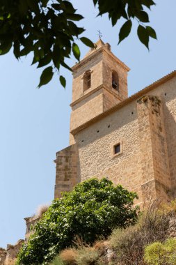 Alcala del Jucar tepesindeki bir kalenin alçak açılı görüntüsü bulutsuz bir gökyüzüne karşı.