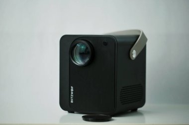 Uzaktan kumandalı Blitzwolf portatif projektörünün beyaz arka planda izole edilmiş bir fotoğrafı.